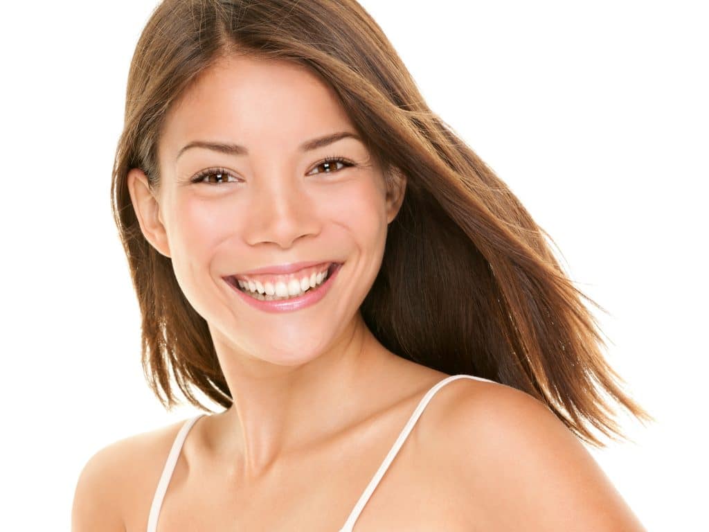 Natural smile. Woman smiling happy - portrait of joyful content girl with big smile. Mixed race Asian Chinese / Caucasian female model in her twenties.